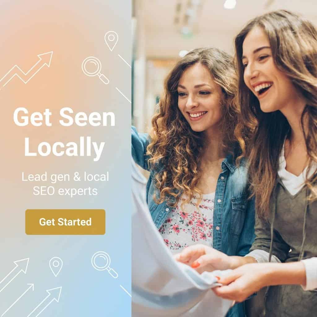 Two women smiling and looking at a tablet, promoting local SEO for clothing boutiques.