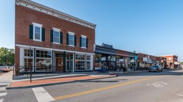 Historic brick buildings in downtown Kansas City with modern storefronts and large windows.