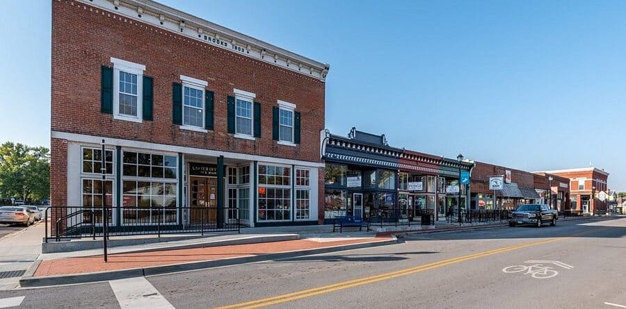 Historic brick buildings in downtown Kansas City with modern storefronts and large windows.